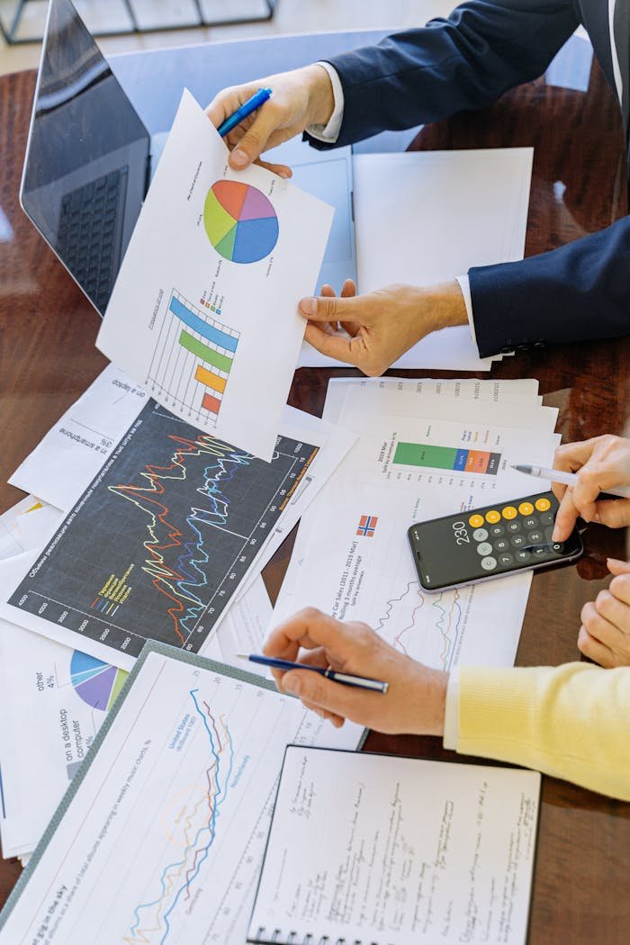 why-choose-us Business professionals analyzing financial charts and graphs during a meeting.